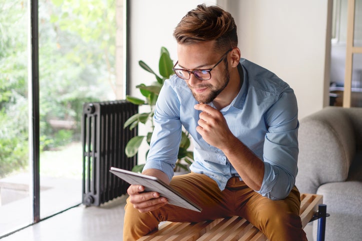 Young adult male looking at digital tablet